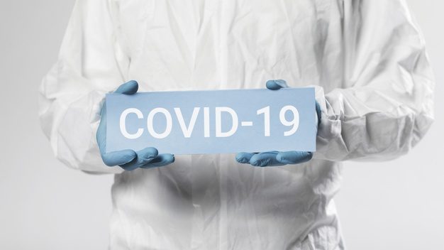 unrecognizable-man-holding-covid-19-card_23-2148445985-626x352